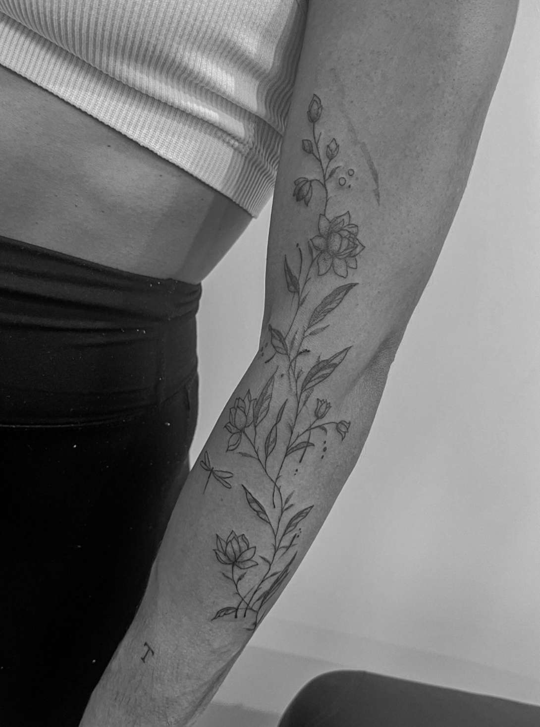 Tatuaje fineline floral en brazo