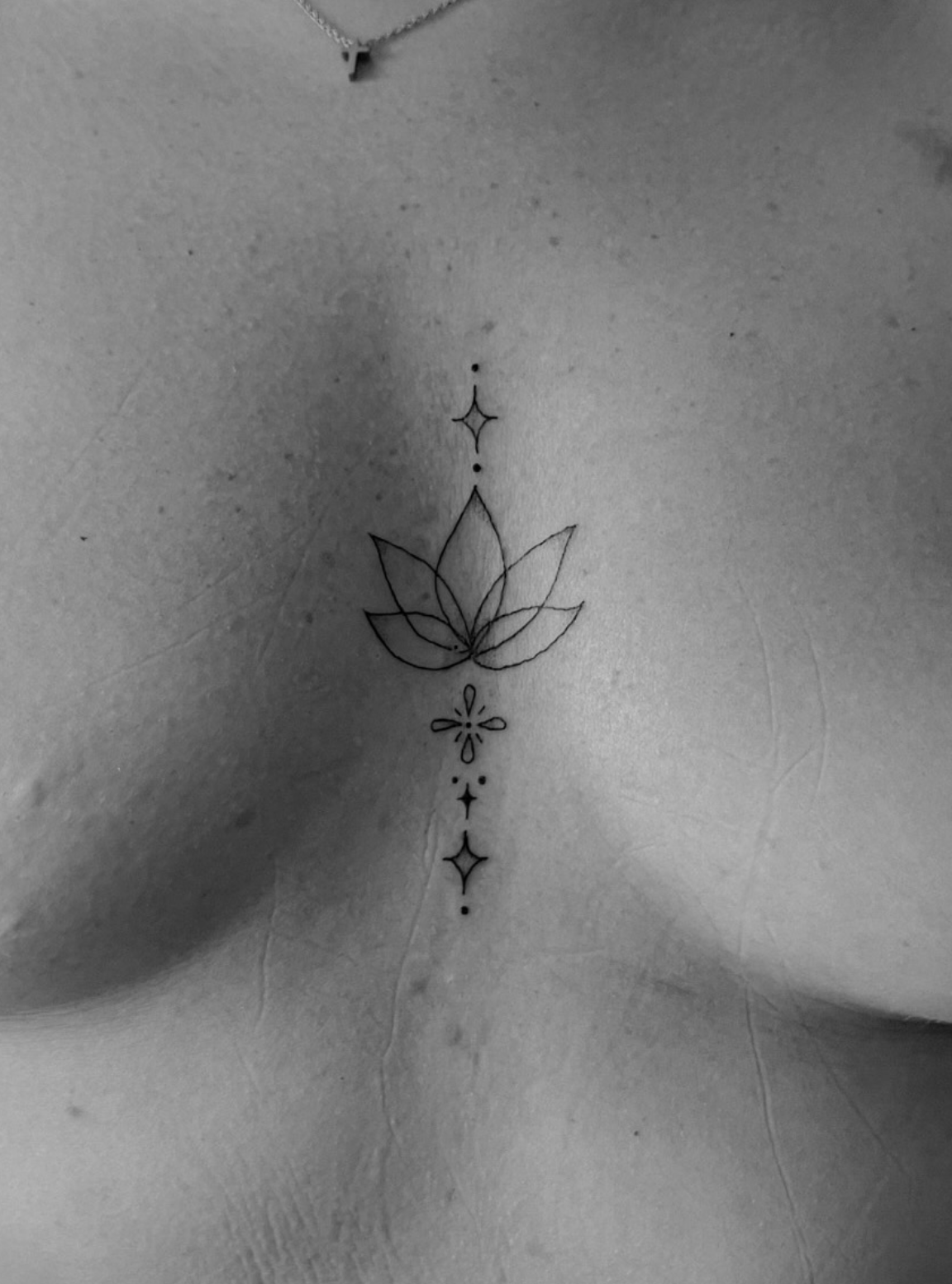 Tatuaje fineline loto en esternón